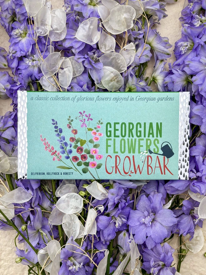 Georgian Flowers Growbar on a bed of Hollyhocks, honesty flowers and delphiniums.  