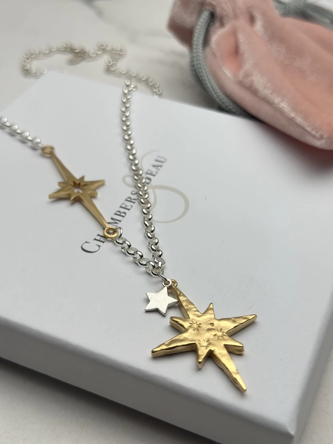 sterling silver chain with horizontal supernova star charm in gold, with a small personalised sterling silver star charm and large gold textured north star