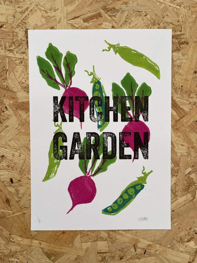 Hand-printed lino kitchen print featuring pea and beetroot illustrations on a wooden table.