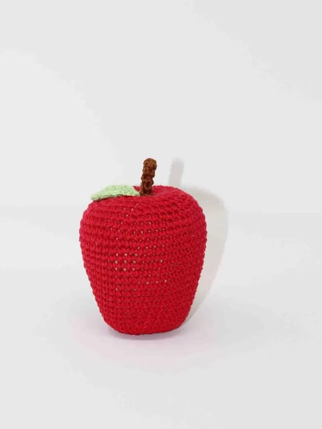 Image of red crochet apple with a plain white background.
