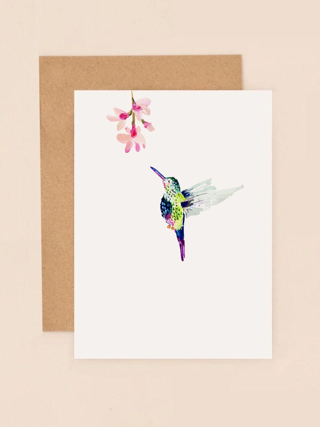 A graceful illustration of a vibrant hummingbird in mid-flight, its iridescent feathers shimmering in hues of green, blue, and pink. The bird hovers delicately against a soft, neutral background, exuding a sense of joy and freedom. The minimalist design captures the elegance of the hummingbird, making it a perfect choice for sending heartfelt messages on birthdays, anniversaries, or as a thoughtful note to brighten someone's day.