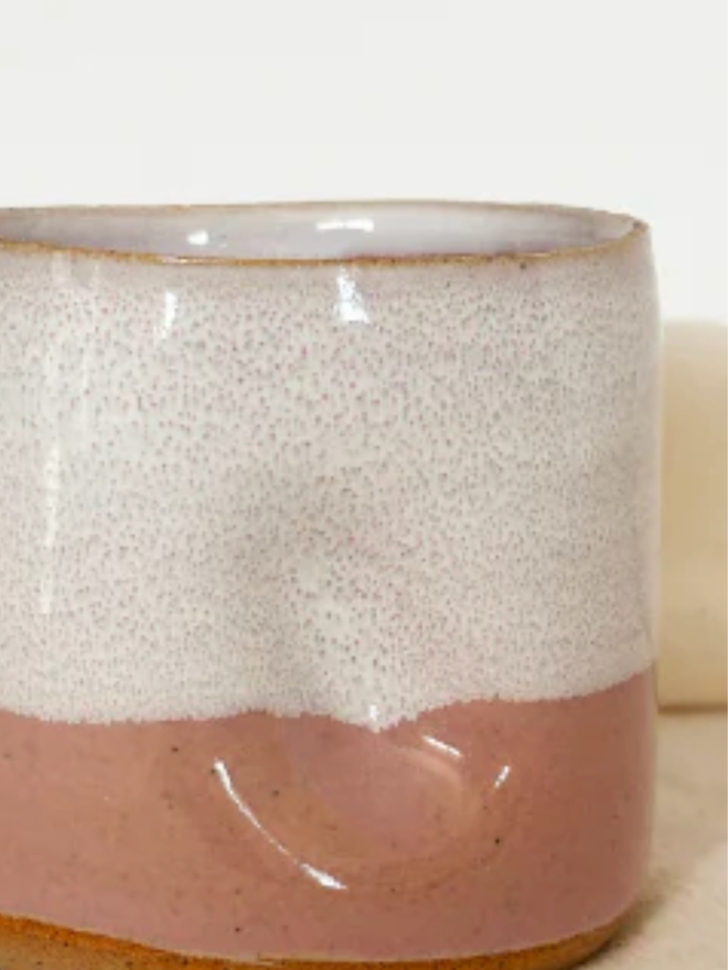 Pinch Mug. A close up of a Pink Dip Mini Pinch Mug against a white and cream background.