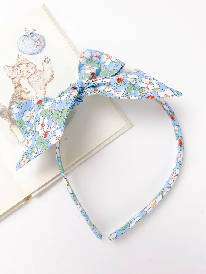 Alice Band with large side bow on a beatrix potter book