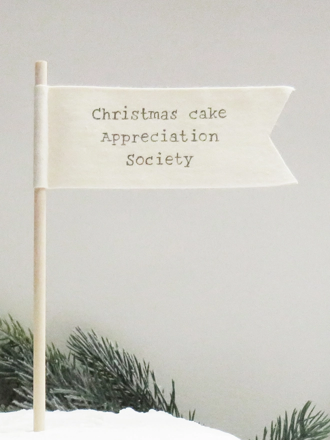 organic cotton flag with hand painted festive message wrapped round wooden dowel.