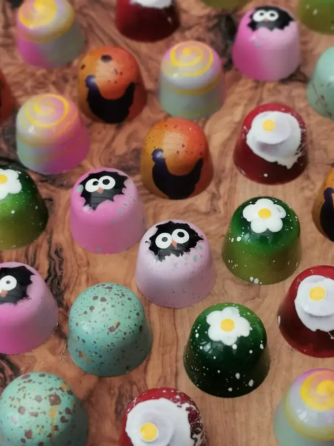 display of colourful easter-themed chocolate bon bons on wooden table