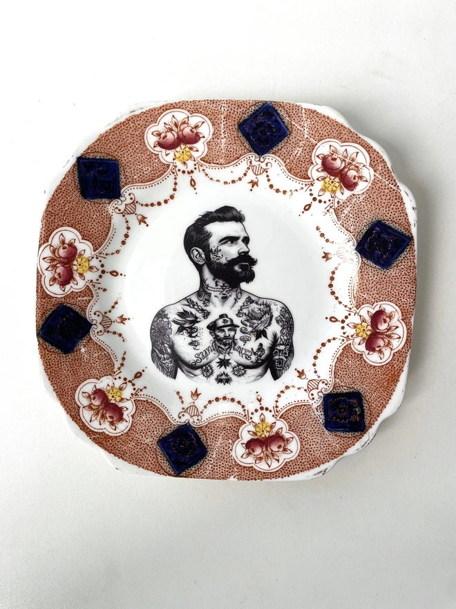 a vintage plate with ornate border, within the centre i have printed the vintage style image of a victorian tattooed sailor man