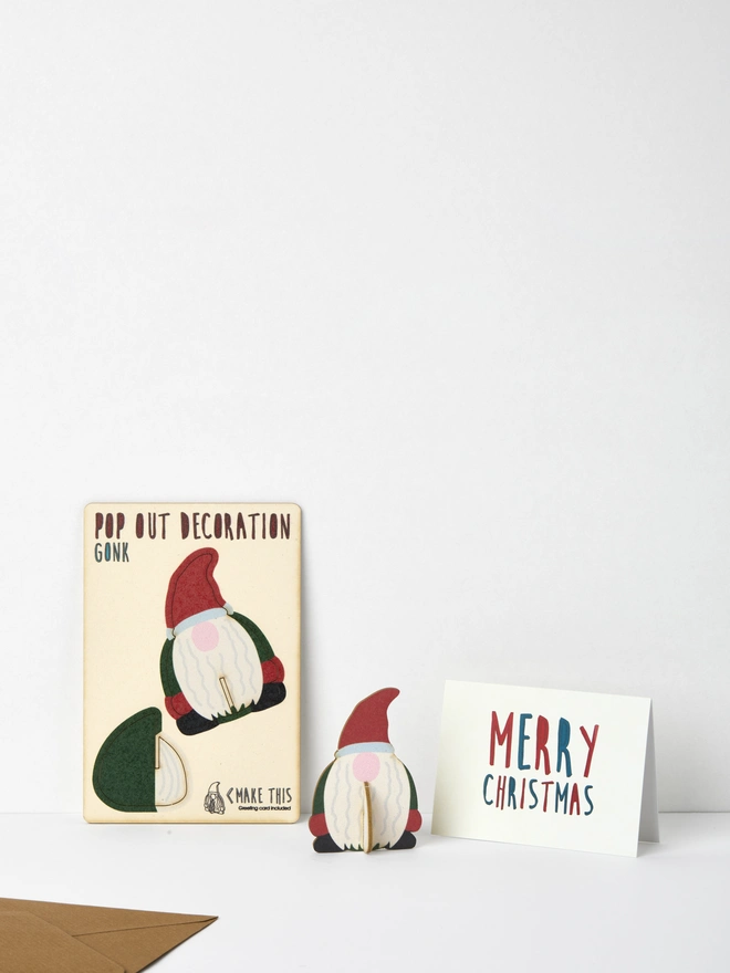 Pop out Gonk Christmas decoration and Merry Christmas card and brown kraft envelope on a white background