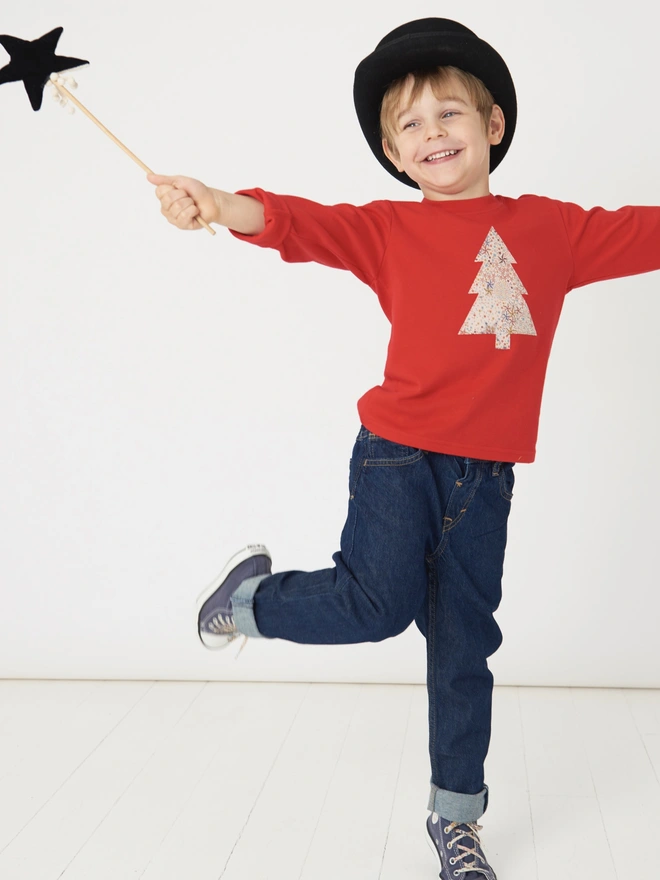 a 4 year old boy wearing a top hat and a festive red tee with a christmas tree cut from starry Adeljada liberty print sewn onto the front