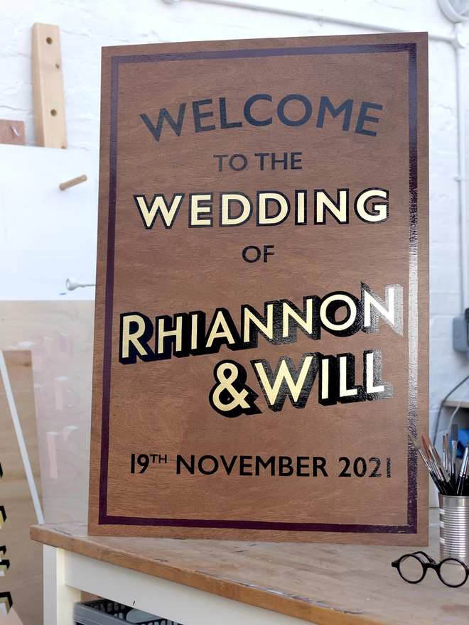 Welcome to the wedding sign with glossy black handpainted letter san gold leaf, shown in the workshop in which it was painted. 