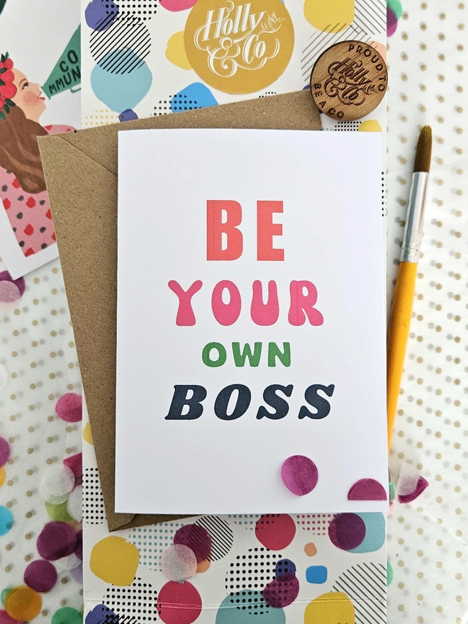A white card with colourful text that says be your own boss
