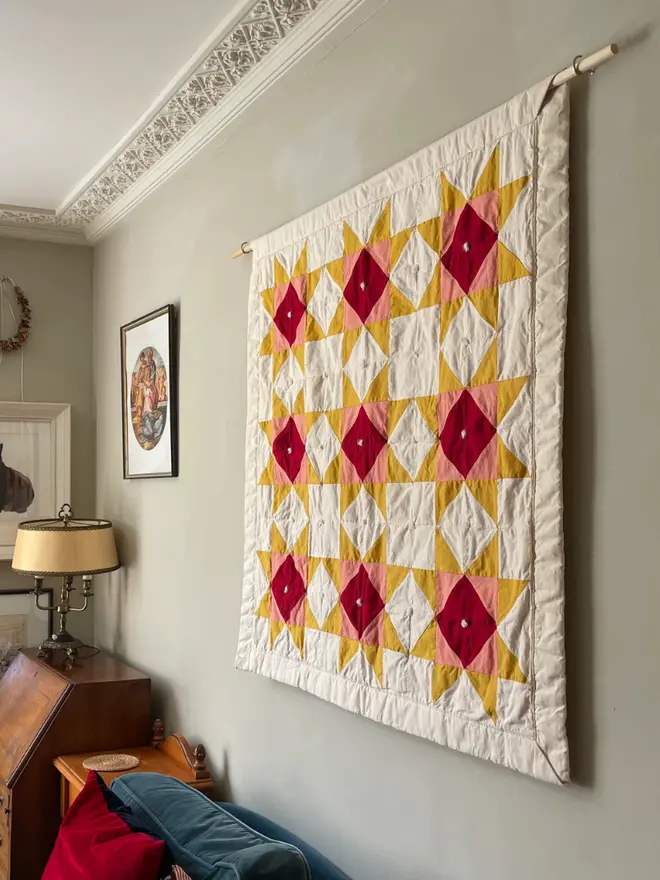 Warm Hearth Patchwork Quilt, on a wall. 