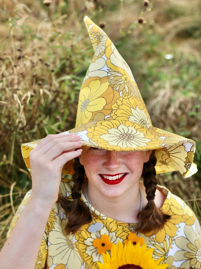 Yellow witch hat worn by girl made from vintage fabric