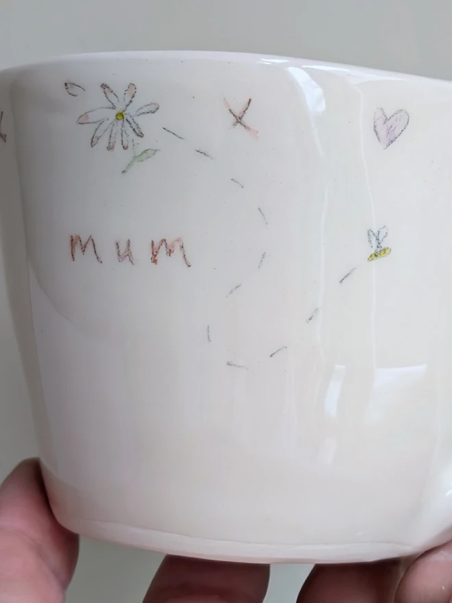 handmade ceramic cup for mum with flowers, daisy hearts and tiny honey bee in white earthenware with pink highlights
