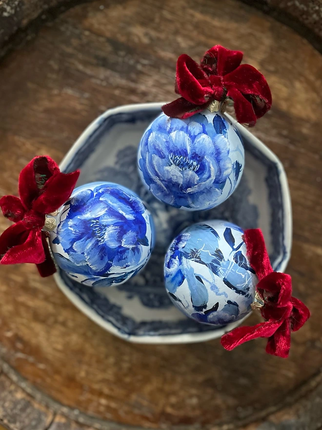hand painted ceramic toile de jouy inspired Christmas bauble rich blues featuring delicate peony flowers 