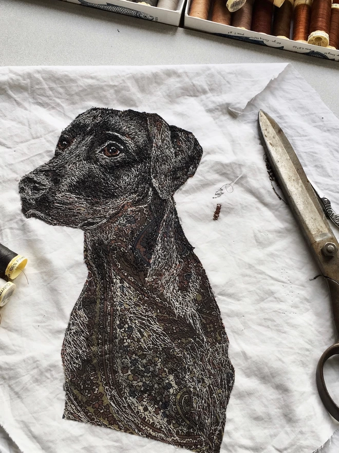 photo showing work in progress on pet portrait of a black lab on the sewing table