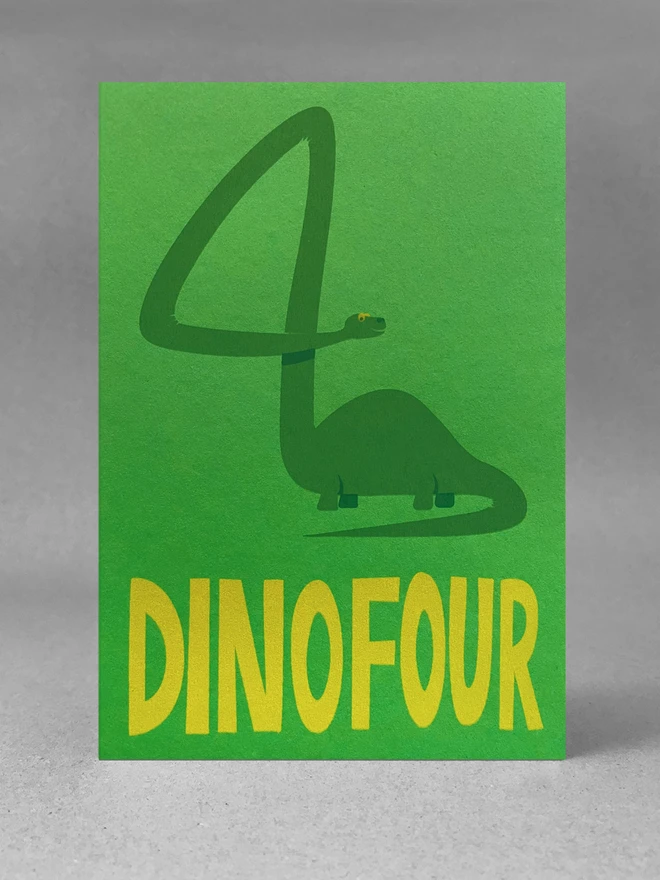 Bright green portrait card on grey background. The number four has been created by the very long-necked, happy dinosaur.The words DINOFOUR are at the bottom in bright Yello type