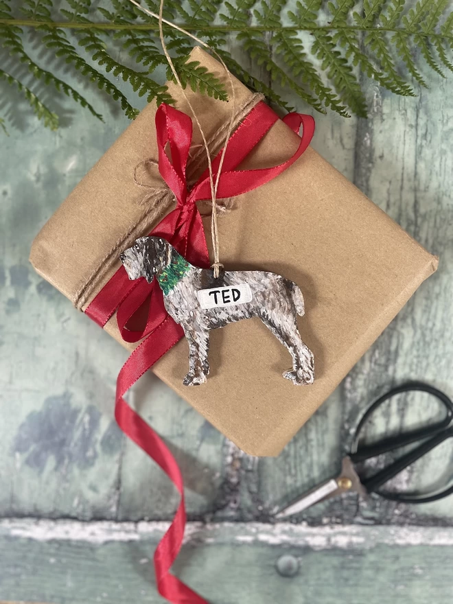 Italian Spinone Dog decoration placed onto a giftwrapped Christmas gift