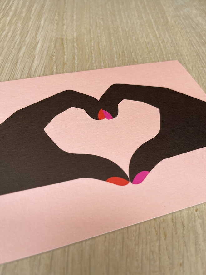 Greetings card with two hands making a heart shape