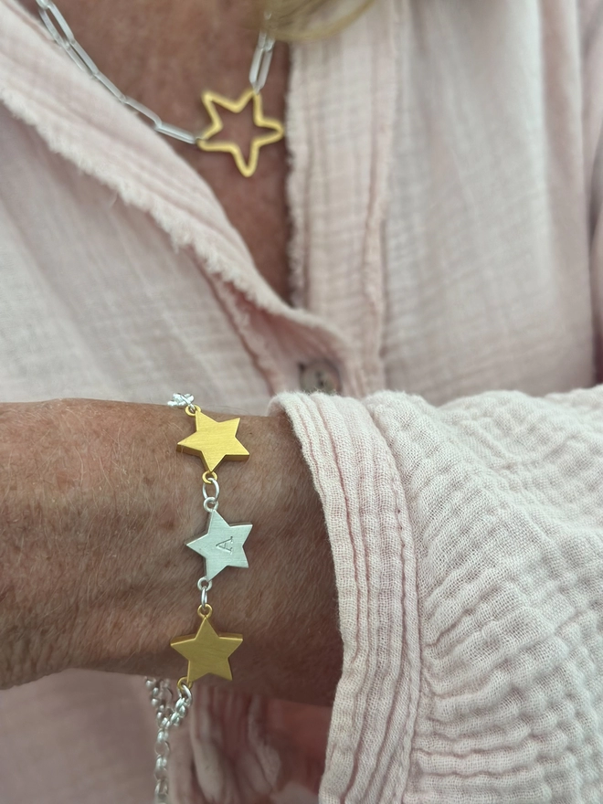 Model wears a trio of stars in mixed metal on silver belcher chain bracelet