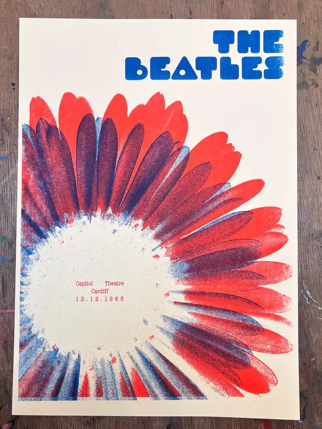 The Beatles Handmade Risograph Gig Poster, against a wooden table.  