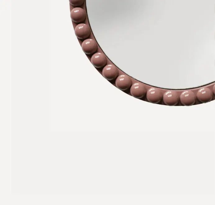 Round oversized bobbin mirror with a decorative bobbin-style wooden frame, hanging on a white wall.