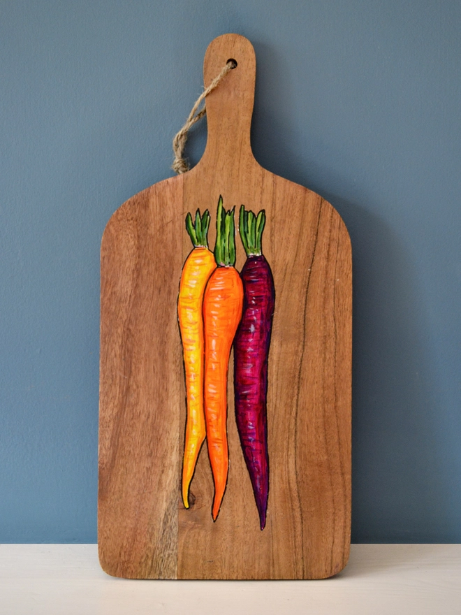 Wooden serving board with a handpainted carrots design