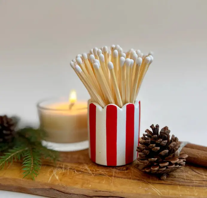 Stripy Match Stick Holders. Coloured matchsticks in a striped, scalloped matchstick holder on a white background.  