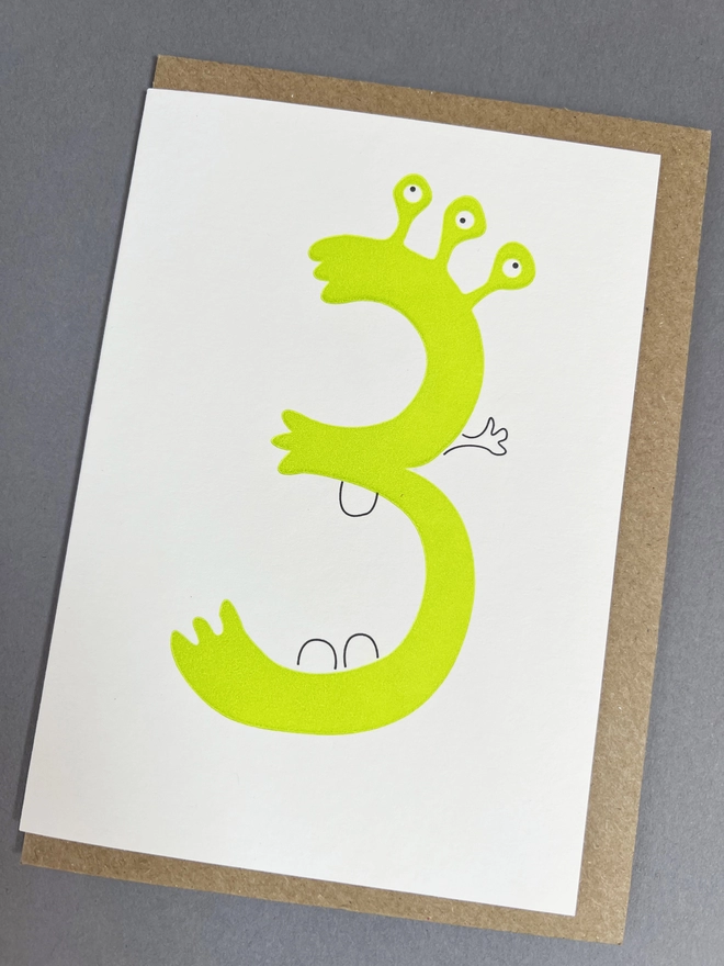 Letterpress printed number three with three eyes and three teeth for children's party
