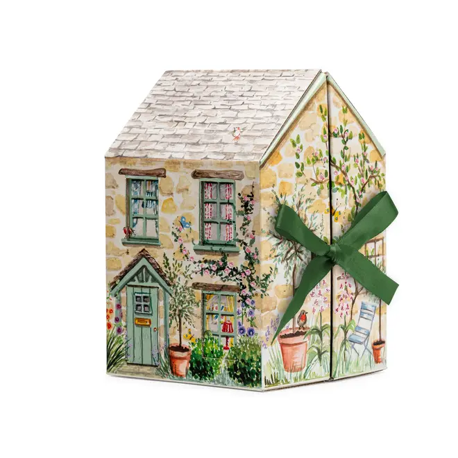 yellow cardboard cottage with illustrated design, with green bow attached