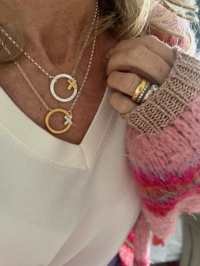 model wears personalised sterling silver halo charm on silver chain with gold kiss charm, and gold open circle hug charm on sterling silver chain with x silver kiss charm