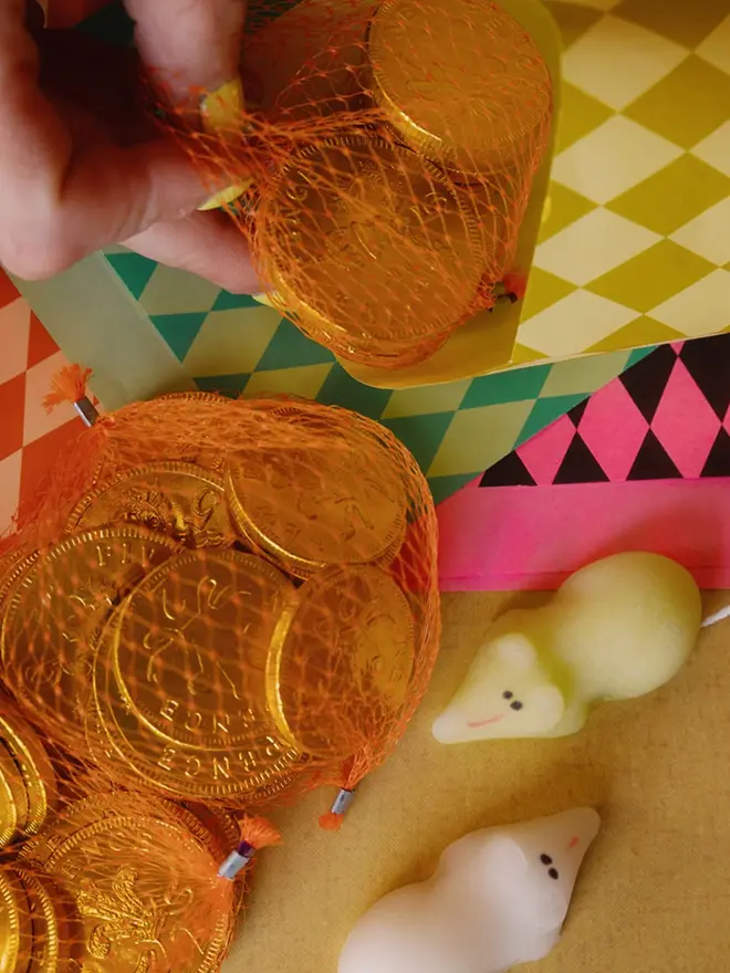 paper party favour bags (pack of 24). chocolate coins and mice being put into party bags.