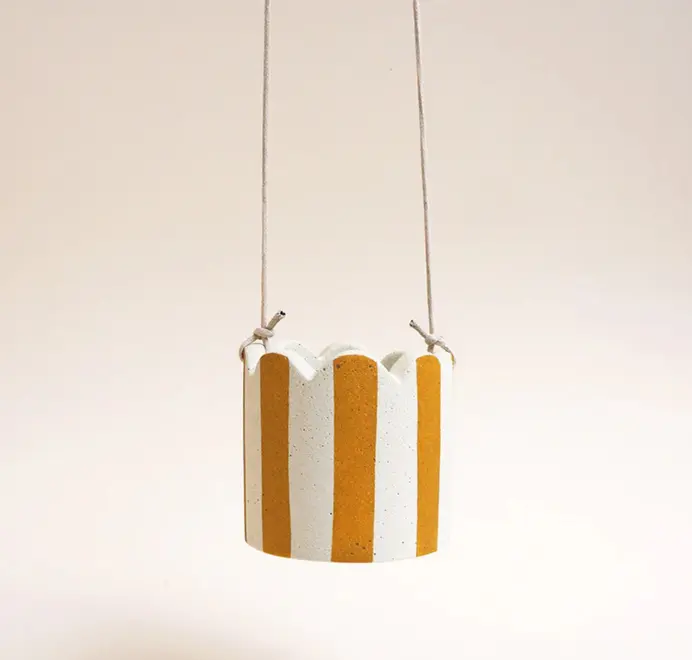 Small Stripy Hanging Plant Pot. White ceramic pot decorated with vertical yellow stripes against a plain light background.