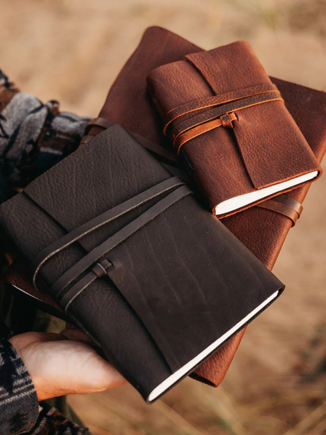 reclaimed saddlery leather journal. a stack of three different sized brown leather  journals.