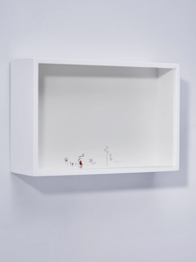 Miniature scene in an artbox showing a tiny boy figurine drawing all over the walls of the white box