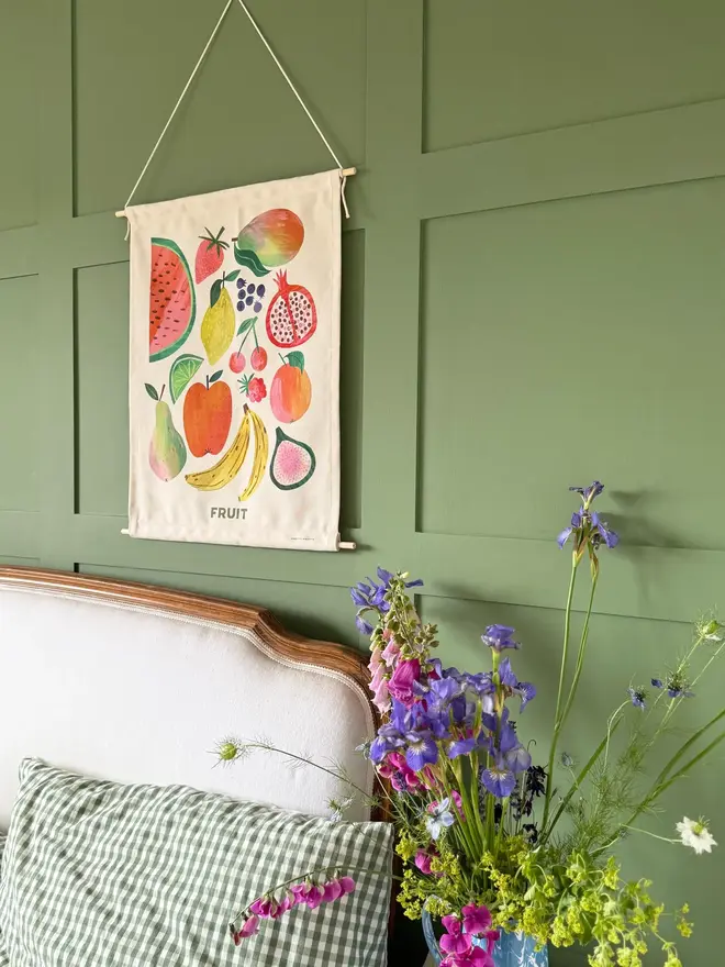Fruit Print Fabric Banner, hanging on a green wall, next to a white head board. 