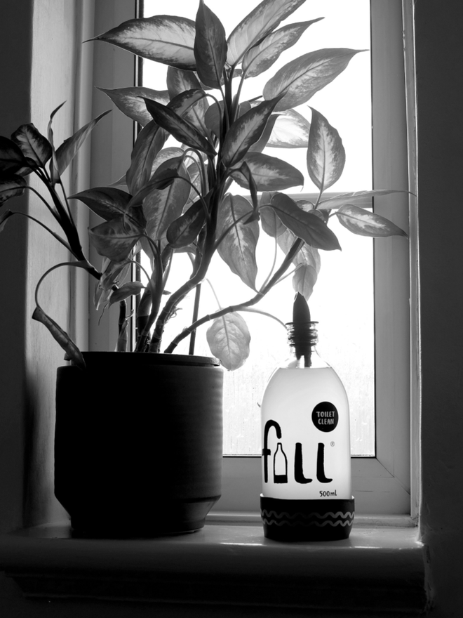 Toilet Cleaner. A bottle of toilet cleaner with a trigger spray on a windowsill.