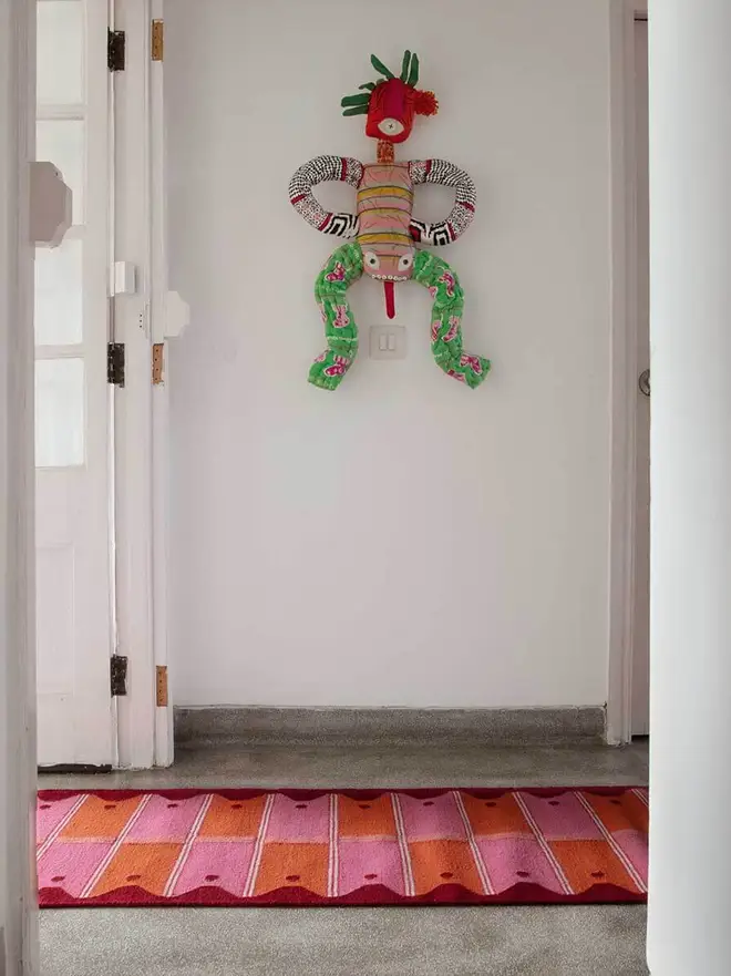 Ladder Flatweave Runner Rug, a colourful rug sitting in a living room. It is accompanied by other household items. 