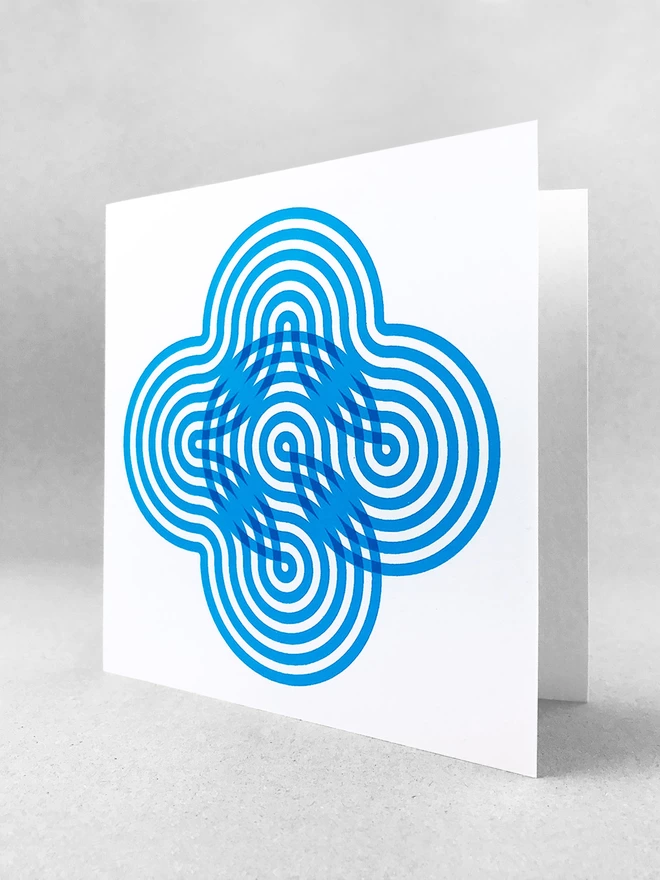  Six blue swirling stripes create a neat flower-like visual on the front of this card. This studio shot shows the card slightly open on a light grey background.
