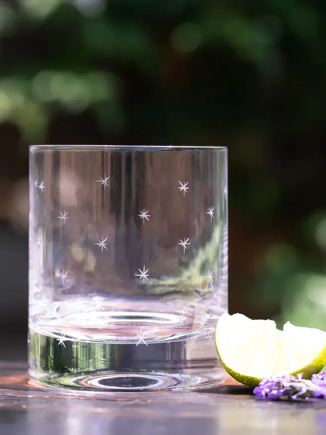 engraved stars crystal whisky glass. a cocktail glass patterned with small stars.