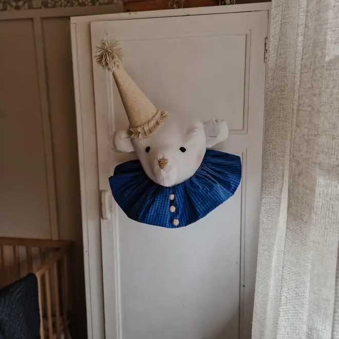 Bear Head Nursery Decoration, a bear decoration sitting against a wall in a child's decorated bedroom. 