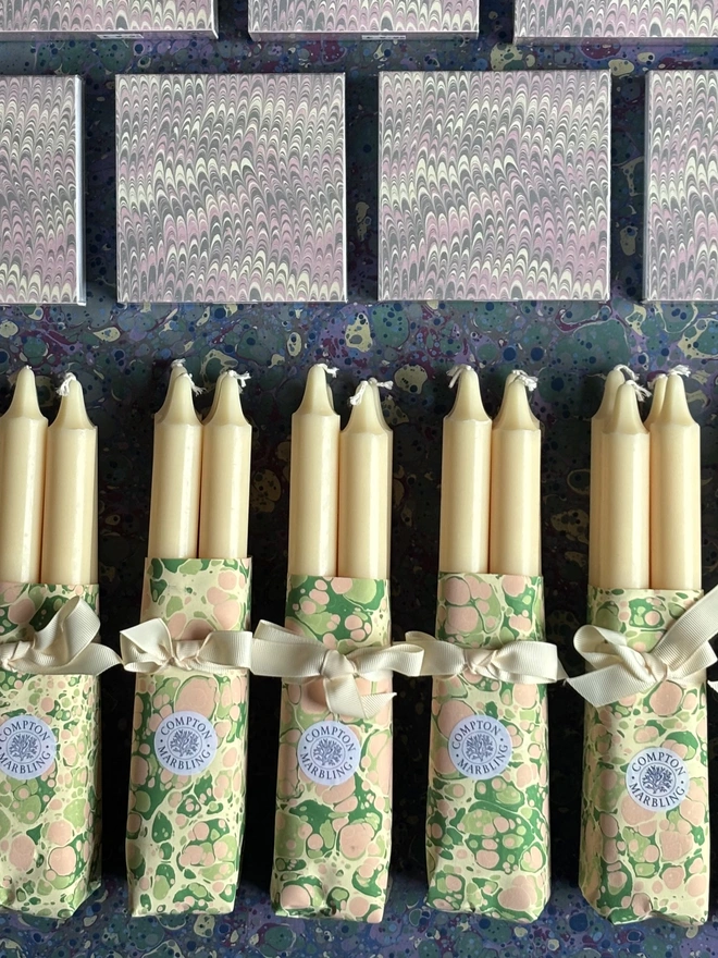 Wrapped candles in hand marbled paper with a square box of matches