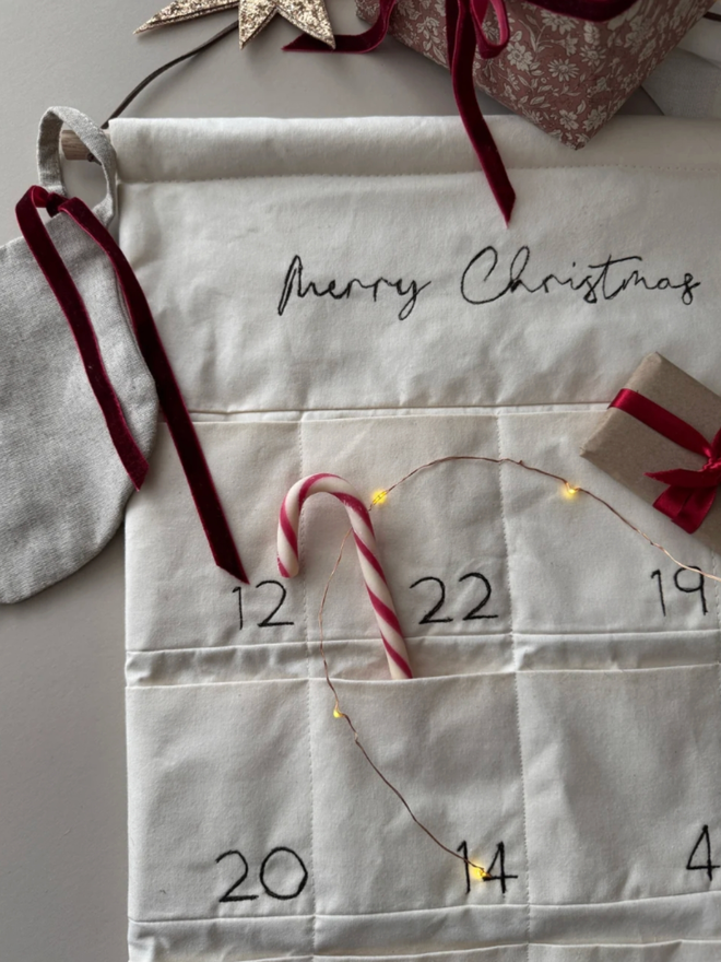 Embroidered Advent Calendar. An advent calendar filled with candy canes and other Christmas treats.