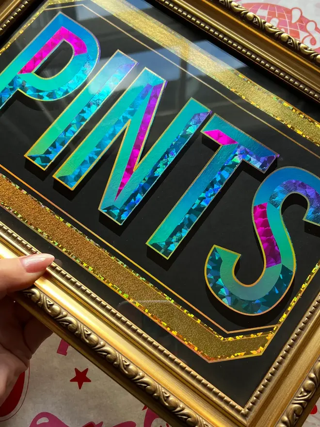 'Pints' ScreenPrint, a colourful screenprint that says 'Pints' held by a person, it sits on a black blackdrop