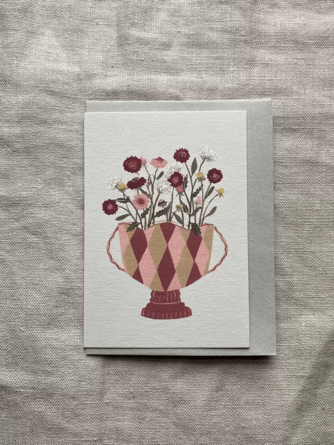 Greetings card with scabiosa flowers in a vase on it.