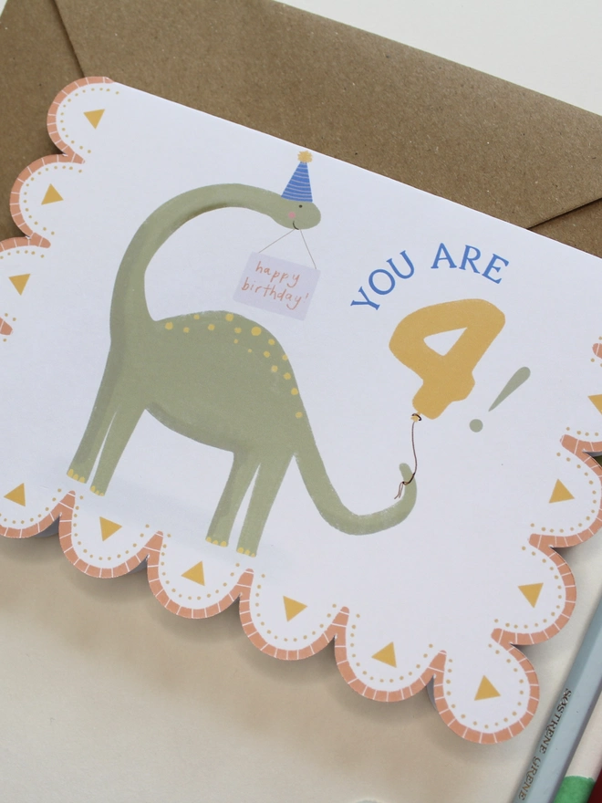 illustrated dinosaur 4th birthday card. scallop edged card 