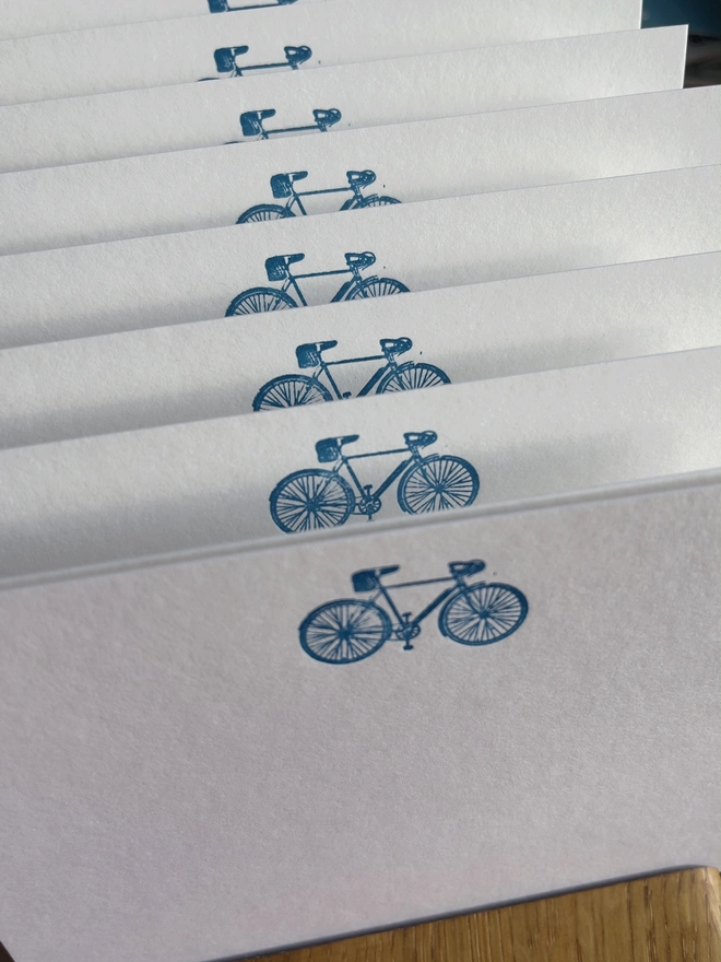 super cool bicycle notecards set. a set of white notecards with blue bicycles illustrated on the top.