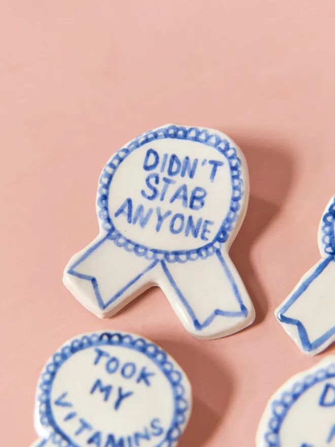  Blue Handmade Ceramic Award, a group of blue and white ceramic award badges sitting on a ink surface. 