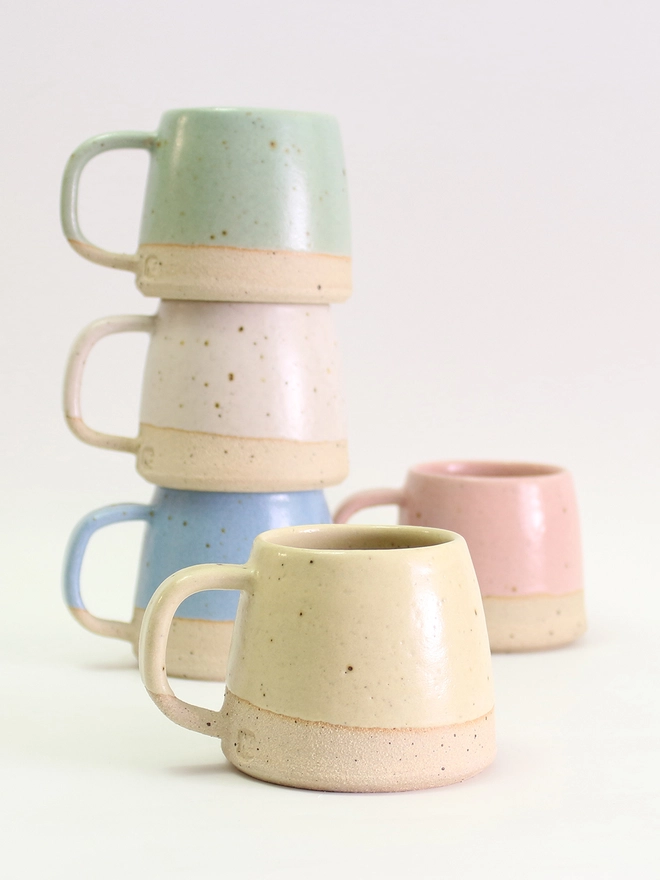 close up of yellow mini mug with stack of other colours behind