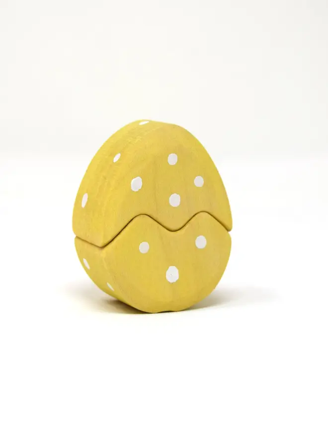 yellow easter egg with white dots. egg can be seperated into 2 pieces