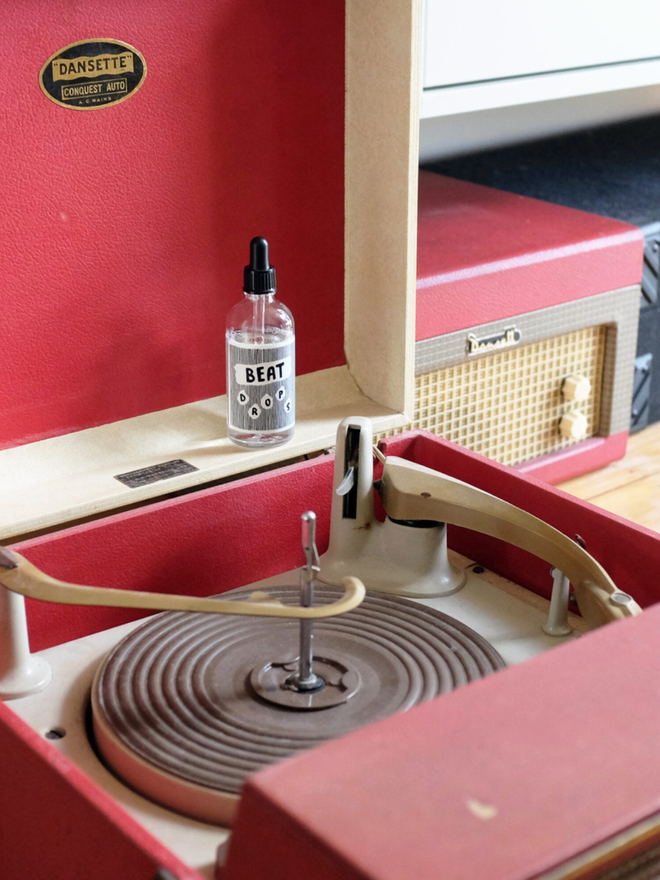 Beat Drops Record Cleaner. A small bottle of record cleaner on a record player.